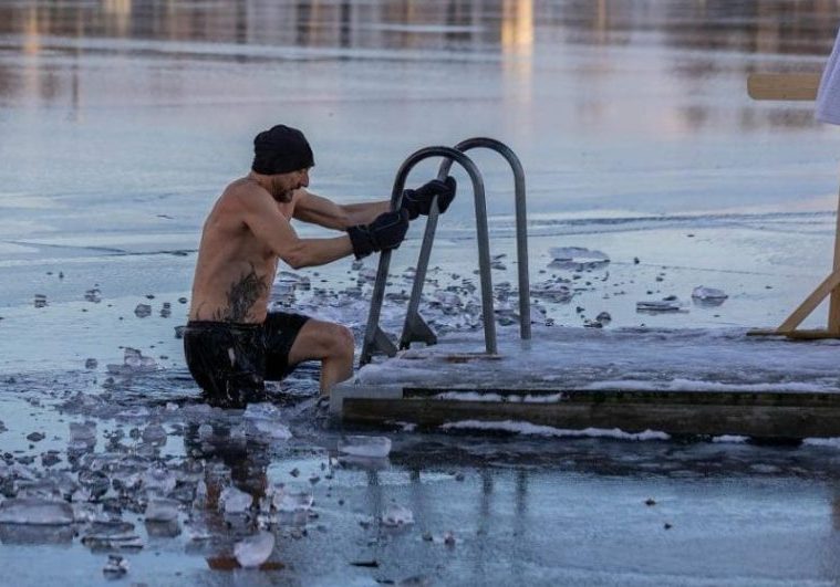 Shirtless man in freezing lake near Ludvika, Sweden, captured during a winter swim. Sublime ice scenery.