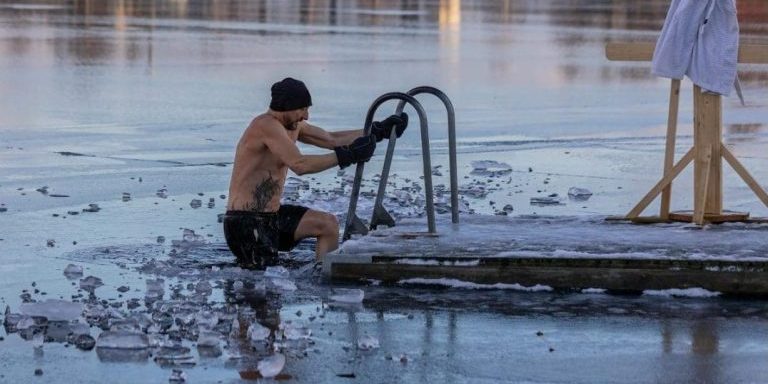 Shirtless man in freezing lake near Ludvika, Sweden, captured during a winter swim. Sublime ice scenery.
